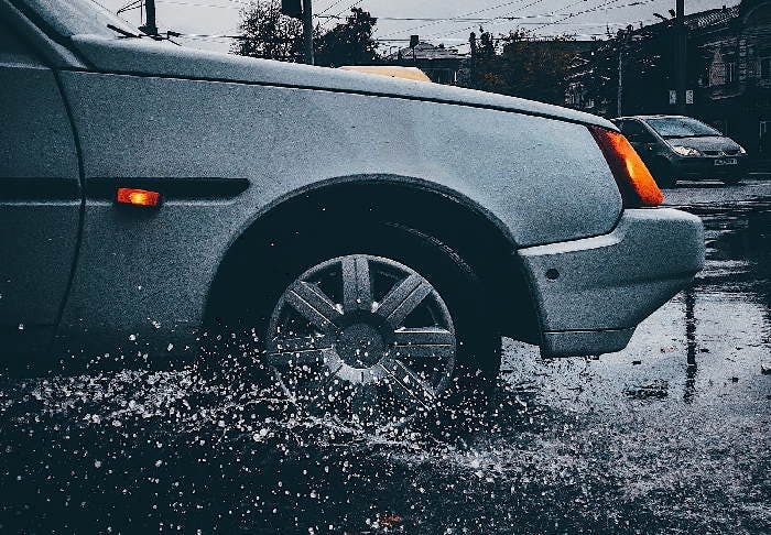 Photograph of a car driving through a deep puddle
