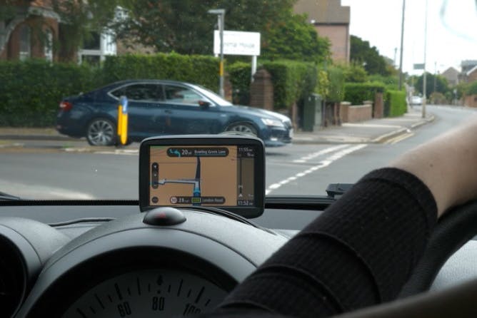 Photograph of somebody sitting a driving test and following directions on a sat nav