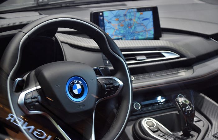 Photograph of a BMW car's interior with an in-built satnav system visible in the background.