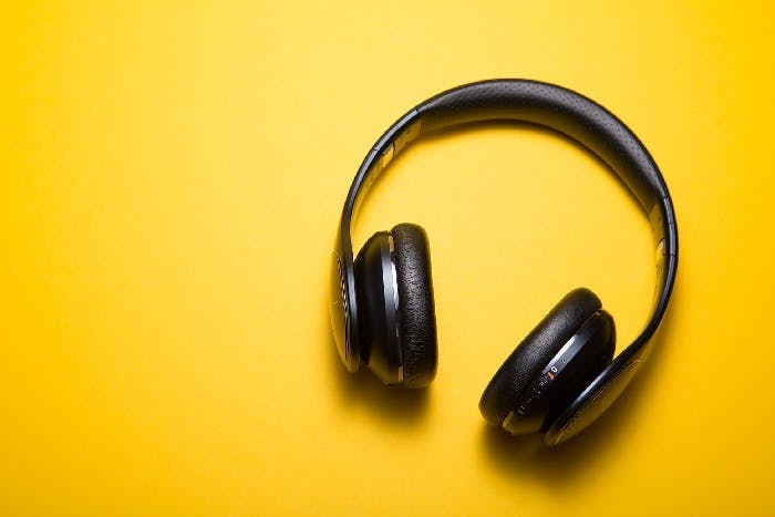 A pair of headphones against an orange background