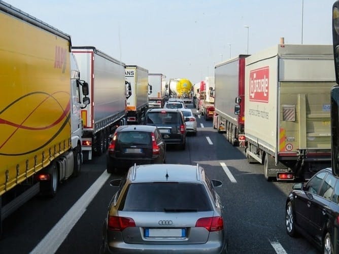 An image of cars and trucks on a motorway stuck in traffic 