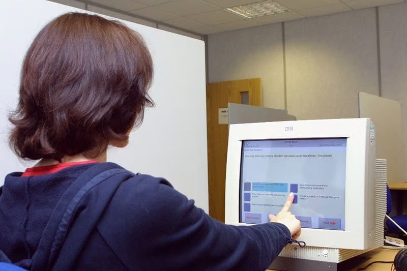 Person completing a theory test in front of a computer screen