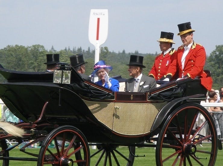 Queen Elizabeth II waving to crowd in a carriage at Ascot