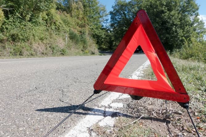 Red warning triangle placed at the side of a road