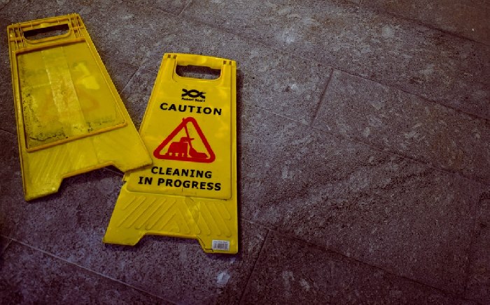 Two 'cleaning in progress' signs on floor