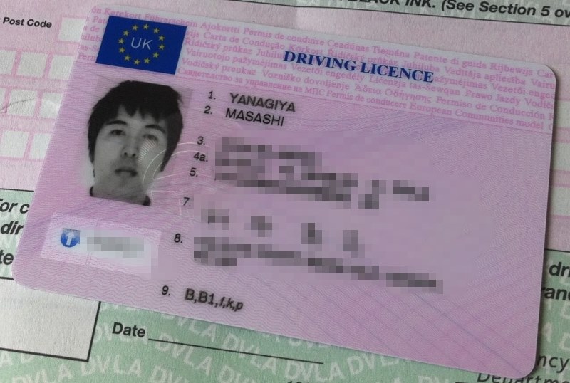 1998-style UK photocard driving licence lying on top of a paper counterpart licence