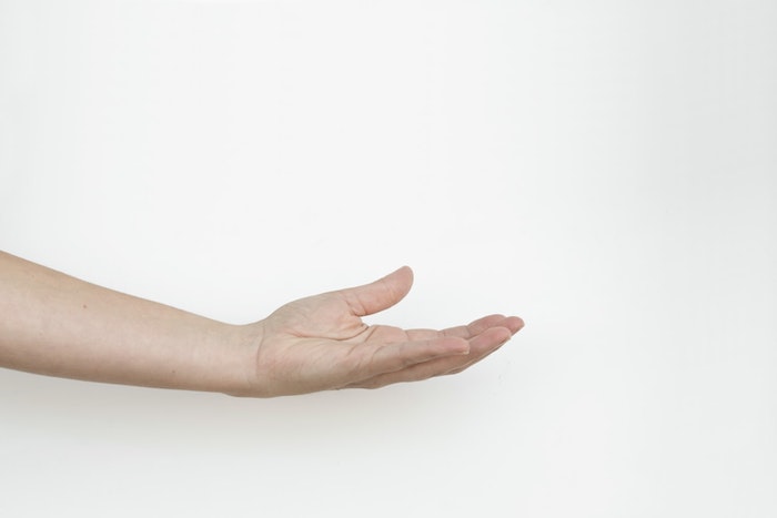 Hand outstretched against white background