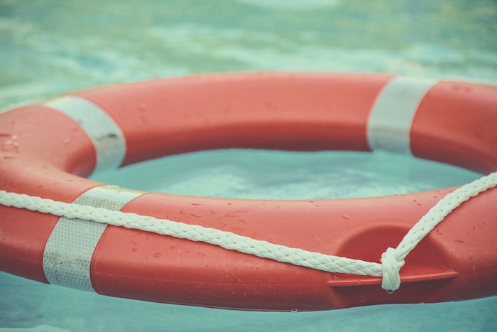 Red and white lifebuoy floating in water