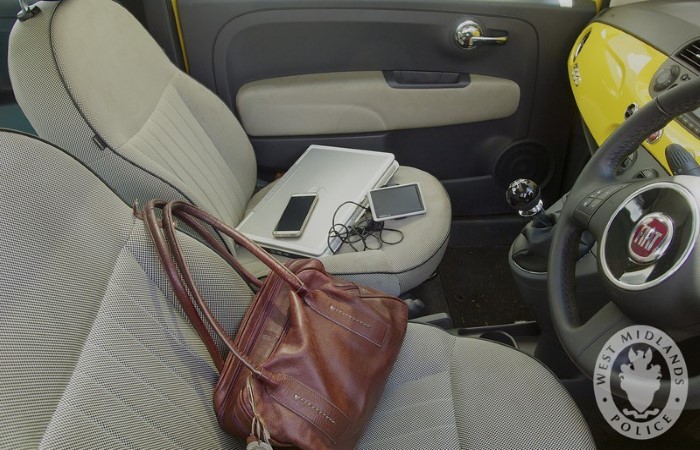 Belongings like a laptop and mobile phone out in the open inside a car